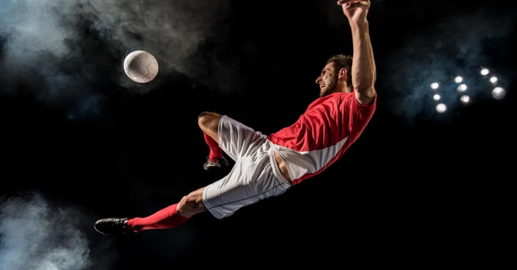Zahipnotyzowany piłkarz nożny w transie sportowym kopie piłkę, chcąc strzelić gola podczas meczu